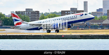 British Airways piano in atterraggio a London City Airport BA Cityflyer Embraer 190 G-LCYM bruciando i pneumatici in gomma su touchdown nei Docklands di Londra REGNO UNITO Foto Stock