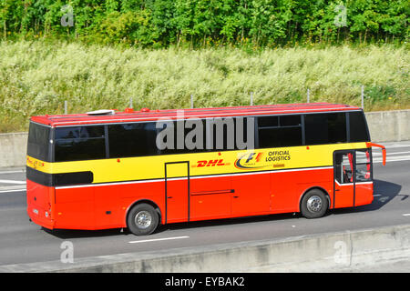 DHL sponsorizzazione di Formula 1 auto racing esposti e pubblicità sulla vista laterale di logistica ufficiale pullman bus guida lungo la strada inglese UK autostrada Foto Stock