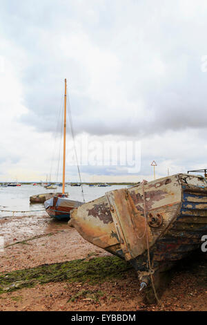 Barca a spiovente con la bassa marea sulla riva a West Mersea, Mersea Island, Colchester, Essex, East Anglia, Inghilterra, Regno Unito. Foto Stock