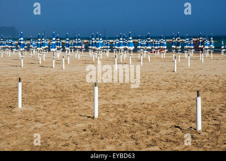 Chiuso blu spiaggia ombrelloni su una spiaggia di sabbia gialla. Foto Stock