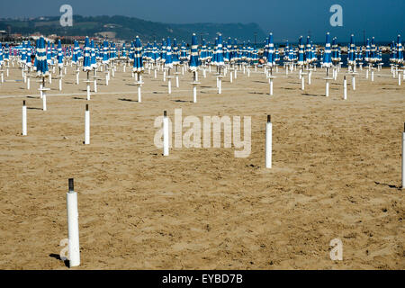 Chiuso blu spiaggia ombrelloni su una spiaggia di sabbia gialla. Foto Stock