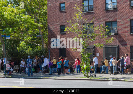 La gente di attendere in linea per libero alimentare distribuito dalla città, raccolto per gli affamati, in Hamilton Heights in New York City. Foto Stock