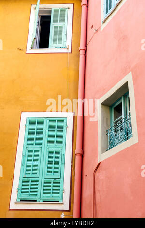 Finestre con persiane alle case vivacemente colorate nella città medievale di Villefranche-sur-Mer sulla Costa Azzurra, Francia. Foto Stock