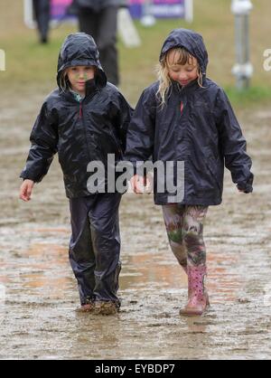 Malmesbury, Wiltshire, Regno Unito. 26 Luglio, 2015. Due bambini a piedi attraverso il fango e la pioggia a Womad Festival tenutosi a Charlton Park, nel Gloucestershire. Il 26 luglio 2015. Credito: Adam Gasson/Alamy Live News Foto Stock