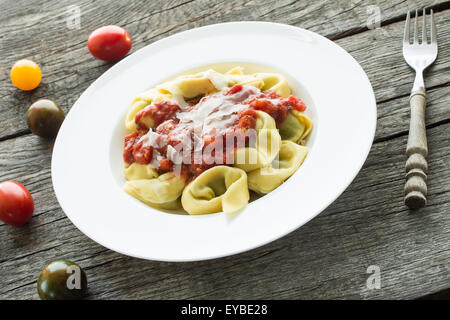 Tortellini con salsa di pomodoro e formaggio parmigiano su una piastra Foto Stock