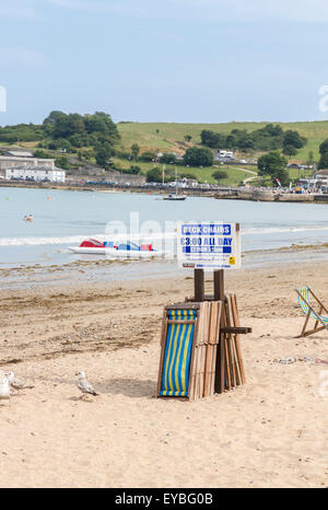 Impilati sdraio sulla spiaggia di Swanage, Isle of Purbeck su Jurassic Coast, Dorset, a sud-ovest dell'Inghilterra in estate Foto Stock