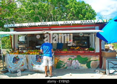 Uomo a comprare prodotti freschi dal mercato stradale stand con vendita di frutta e verdura presso locali colorati stand di vendita. Foto Stock