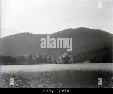 Antique c1920 fotografia dei Balsami Grand Resort Hotel sul Lago Gloriette in Dixville Notch, New Hampshire, Stati Uniti d'America, con il torreggiante Hampshire casa a destra. Foto Stock