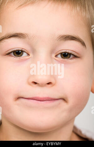 Close-up di annoiarsi-cercando sei anno vecchio ragazzo Foto Stock