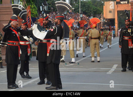 Rangers Pakistani (indossando divisa nera) e il confine indiano forza di sicurezza (BSF) durante una parata giornaliera al giunto Pakistan-India check-post a Wagah border. India e Pakistan solennemente abbassato le loro bandiere nazionali a un tramonto cerimonia militare sulla loro terra principale di attraversamento di confine. La bandiera di cerimonia di abbassamento è estremamente popolare su entrambi i lati, con folle ogni giorno fuori di imballaggio bleachers impostato su entrambi i lati delle gate ornato da grandi rivolta verso i ritratti dei loro padri fondatori, il Mahatma Gandhi sul lato indiano e Mohammed Ali Jinnah sul lato pakistano. (Foto di rana Sajid Hussain/Pa Foto Stock