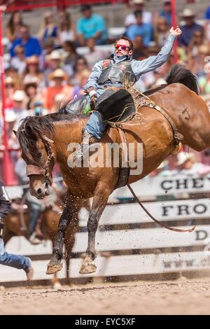 Cheyenne, Wyoming negli Stati Uniti. 26 Luglio, 2015. Bareback rider Caleb Bennett pende sul suo bronco durante il Bareback campionati a Cheyenne Frontier Days rodeo nel Parco di frontiera Arena Luglio 26, 2015 in Cheyenne Wyoming. Giorni di frontiera celebra le tradizioni del cowboy del west con un rodeo, parata e fiera. Foto Stock