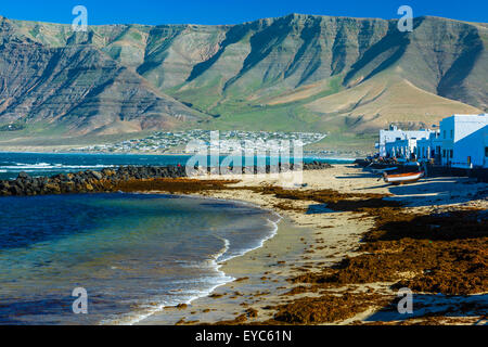 Spiaggia e del villaggio. Caleta de Famara, Lanzarote, Isole canarie, Spagna, Europa. Foto Stock