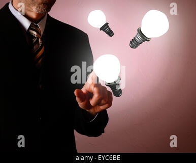 Business man puntando su un bulbo di luce nuova idea concept Foto Stock