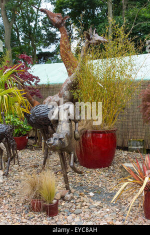 Una collezione di ornamenti giardino di grandi dimensioni animali in acciaio giraffe statue in un giardino suburbano center Foto Stock