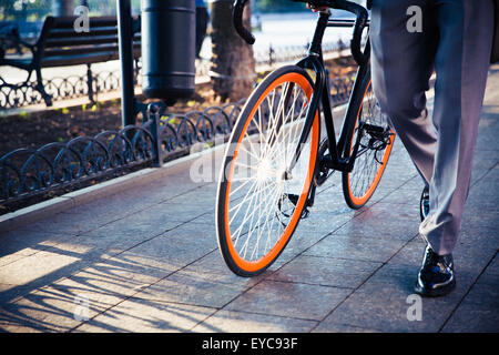 Closeup ritratto di un imprenditore camminando con la bicicletta Foto Stock
