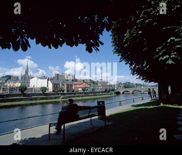 Enniscorthy, Fiume Slaney, Co Wexford, Irlanda; Uomo seduto su una panchina nel parco che si affaccia su un fiume Foto Stock