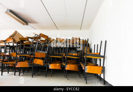 Vecchia sedia abbandonata modulo in aula della scuola. Foto Stock