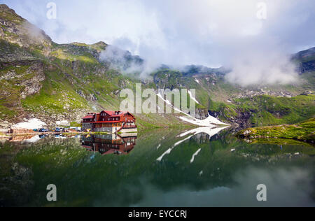 Lago BALEA, Romania - 24 giugno 2012: visione idilliaca con tipici cottage sul lago Balea shore in montagna Fagaras, Romania. Foto Stock