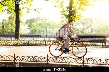 Bello imprenditore Bicicletta Equitazione di lavorare in posizione di parcheggio Foto Stock