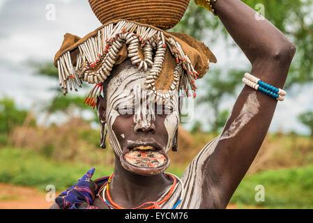 Una donna dalla tribù africana Mursi con grande piastra a labbro nel suo villaggio. Foto Stock