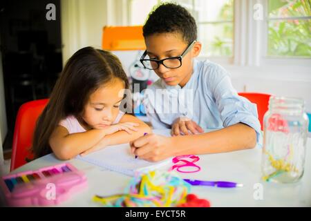 Un ragazzo e una ragazza matita disegno al tavolo della cucina Foto Stock