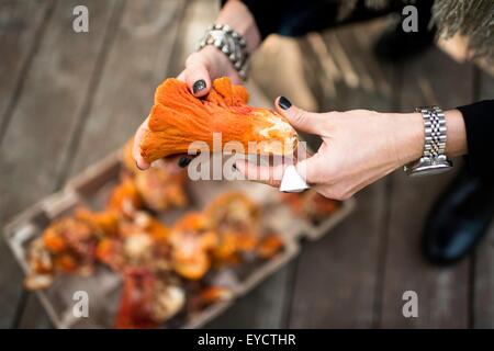 Womans mani tenendo testa a fungo di aragosta Foto Stock