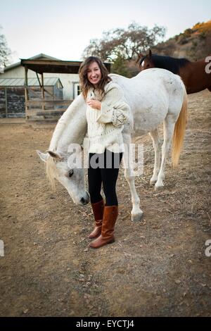 Ritratto di giovane donna petting White Horse Foto Stock