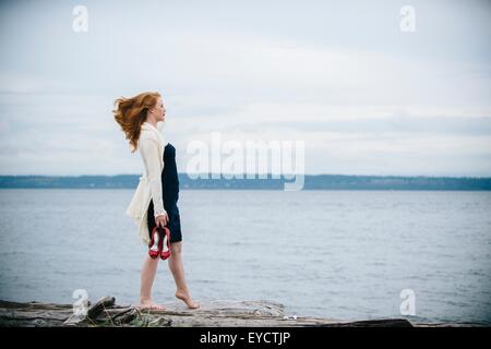 Giovane donna sulla spiaggia che guarda al mare, Bainbridge Island, nello Stato di Washington, USA Foto Stock