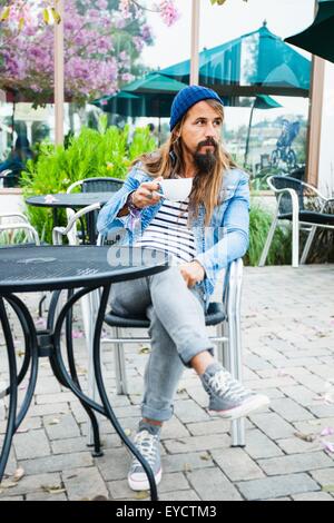Metà uomo adulto seduto nella caffetteria con caffè Foto Stock