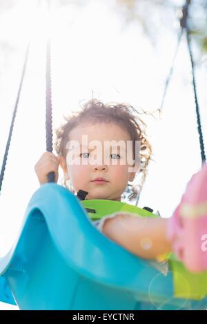 Giovane ragazza sul parco giochi altalena, basso angolo di visione Foto Stock