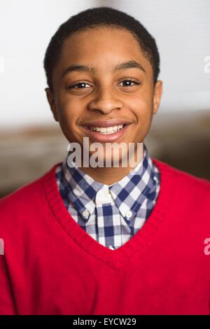Ritratto di sorridere ragazzo adolescente che indossa un maglione rosso Foto Stock