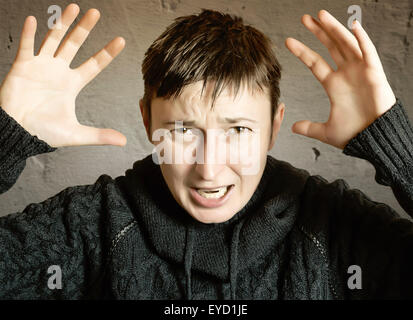 Arrabbiato donna su sfondo scuro. Messa a fuoco selettiva Foto Stock