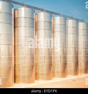 Serie di recipienti di acciaio inossidabile per il vino, il sole al tramonto Foto Stock
