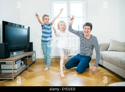 Padre e figli si divertono con aeroplani di carta Foto Stock