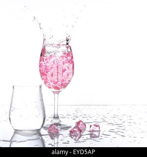 Di gambi di vetro di champagne con il liquore schizzi fuori, isolato su sfondo bianco Foto Stock