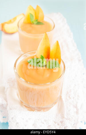 Frullato di pesche dessert con la menta sul tovagliolo bianco Foto Stock