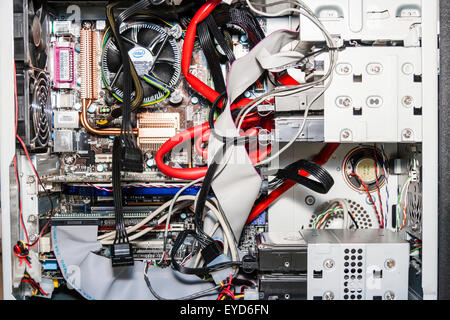 Interno del case del computer con la scheda madre e i processi ventola, plus dissipatori in rame, i cavi e il cavo a nastro e dischi rigidi. Ingombra. Foto Stock