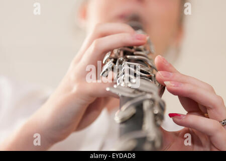 Ragazza che gioca un clarinetto - close up e focalizzata sulle dita. Foto Stock