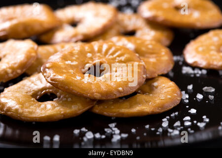 Crackers cookie e diffondere il sale su una piastra scuro Foto Stock