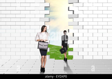 Bella imprenditrici guardando fatiscenti e parete di mattoni Foto Stock