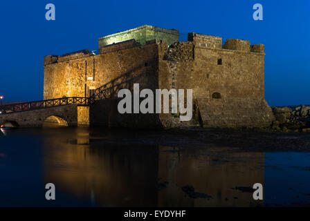 Illuminato il castello di Pafo situato nel porto di notte con il riflesso nell'acqua, Cipro Foto Stock