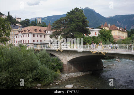 Ponte della Posta (ponte) oltre il Fiume Passirio, nel sud della città tirolese di Meran-Merano, meglio conosciuta per le sue terme, situato in una conca circondata da montagne in piedi fino a 3,335 metri (10,942 piedi) sopra il livello del mare, all'ingresso della Val Passiria e la Val Venosta. In passato il paese è stato un popolare luogo di residenza per vari scienziati, letteraria di persone e artisti tra cui Franz Kafka, Ezra Pound e Paul Lazarsfeld, che hanno apprezzato il suo clima mite. Foto Stock