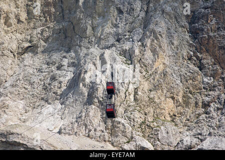 Dal Passo Falzarega (PASS), due funivia gondole passare ogni altro sulla parete di roccia del Lagazuoi (3.244 m), una di montagna delle Dolomiti in Alto Adige, Italia. Uno dei due gondole sorge al Lagazuoi (2,835), che è stata oggetto di pesanti combattimenti nella guerra mondiale I. Lagazuoi è una montagna nelle Dolomiti dell Italia settentrionale, giacente ad una altitudine di 2,835 metri (9,301 piedi), circa 18 chilometri (11 miglia) a sud-ovest di strada da Cortina d'Ampezzo nella regione Veneto. È raggiungibile con la funivia e contiene il Refugio Lagazuoi, un rifugio di montagna si trova oltre l'angolo nord-ovest di Cima del Lago. Foto Stock
