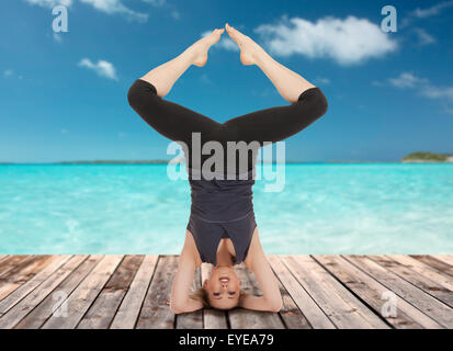 Felice giovane donna facendo esercizio di yoga Foto Stock