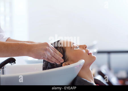 Felice giovane donna al parrucchiere Foto Stock