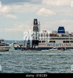 Il Team di Land Rover BAR Coppa America battello passa un Wight Link traghetto per auto durante la Coppa America World Series a Portsmouth Foto Stock