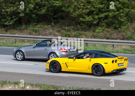 Giallo Chevrolet Corvette e argento Mercedes Benz Roadster movimento veloce in autostrada Foto Stock