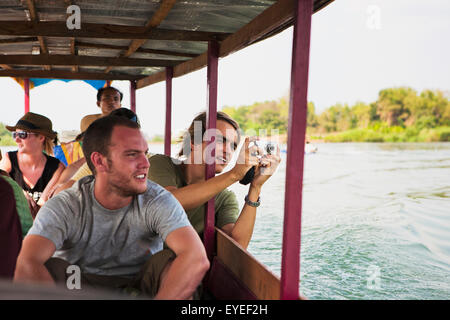 I turisti prendere un traghetto sul Fiume Mekong per l'isola di Don Det; Laos Foto Stock