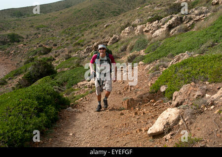 Un escursionista passeggiate lungo uno sperone nord del sentiero costiero di Cami de Cavalls bridal trail sull isola di Minorca spagna Foto Stock