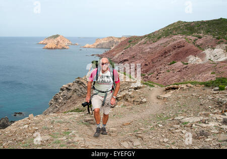 Un escursionista passeggiate lungo uno sperone nord del sentiero costiero di Cami de Cavalls bridal trail sull isola di Minorca spagna Foto Stock